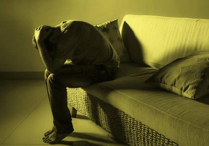 年轻的绝望的悲伤和沮丧的男人在家沙发上悲伤,患有抑郁问题和焦虑
