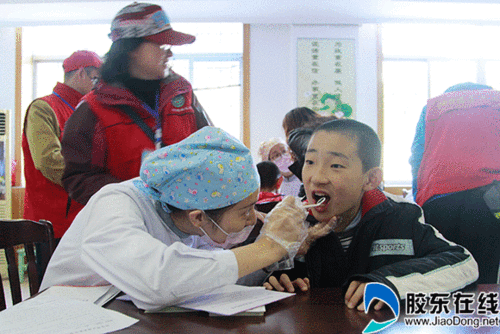 志愿者为自闭症儿童做口腔健康检查
