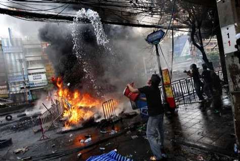 一名红衫军民众试图扑灭电线杆上的大火.