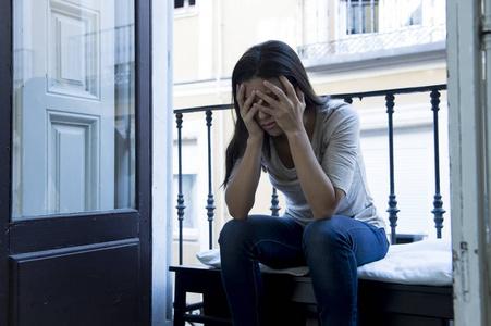 绝望的拉丁女人,坐在家里的阳台上被毁坏, 神情沮丧患上抑郁症照片