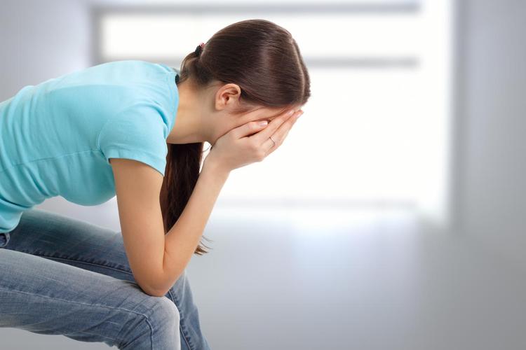 忧郁症少女独自在房间里哭泣患有抑郁症年轻妇女在她的治疗师办公室