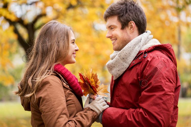 爱情关系季节和人的概念快乐的年轻夫妇枫树叶在秋天的公园