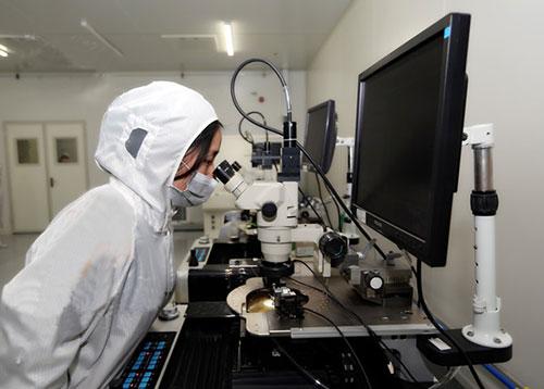中心工作人员正在对芯片进行测试,测试过程中通过显微镜观察芯片的