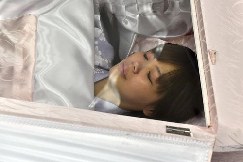 日本殡葬展上 参观者躺棺材里进行用户体验