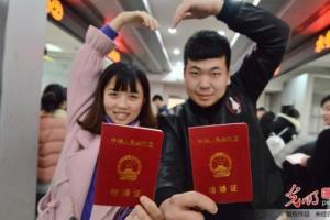 一对新人在河北省邯郸市邯山区民政局婚姻登记处展示刚刚领取的结婚证