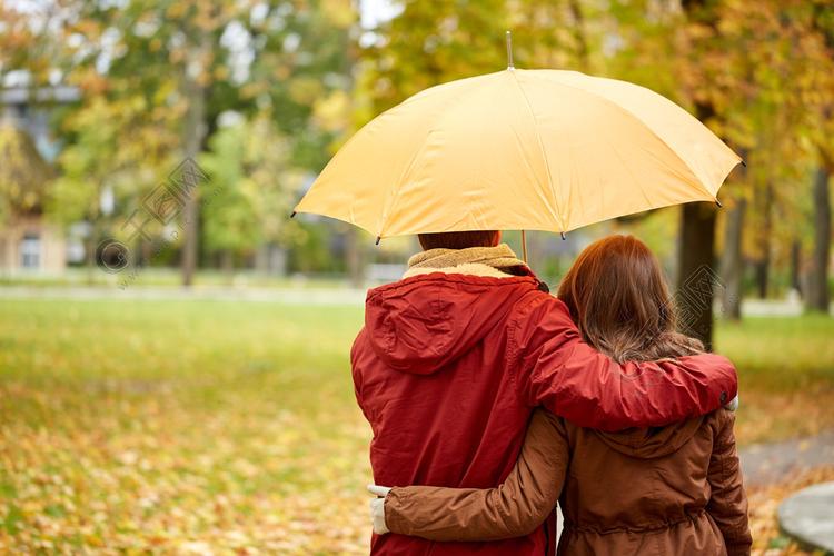 爱情,关系,季节,家庭和人的概念— —幸福的夫妇,带着伞走在秋天的