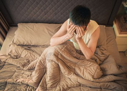 沮丧男子背影亚洲男子在床上患有抑郁症背景