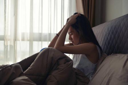 亚洲女人患上抑郁症坐在床上照片